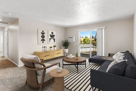 A living room with a grey couch, a wooden chair, and a coffee table at The Overlook Apartments in Post Falls, ID.