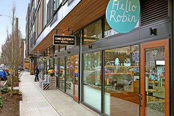 A paved sidewalk lined with shops leading to 19th & Mercer Apartments.at 19th & Mercer, Seattle, WA