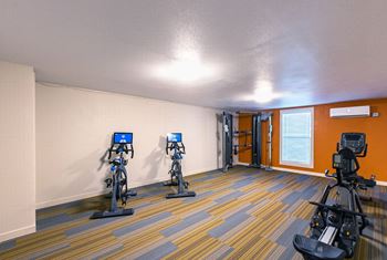 Fitness center with stationary bikes, a cable machine and rowing machine at Park View Apartments, Wenatchee