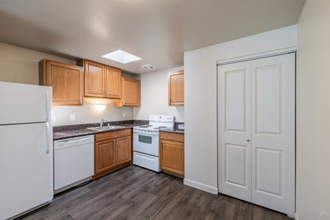 A kitchen with white appliances and wooden cabinets.