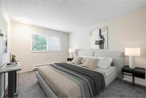 A bedroom with a large bed, a nightstand with a lamp, and a painting on the wall.