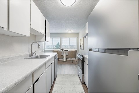 A modern kitchen with white cabinets and stainless steel appliances.