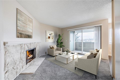 Living room at Peak 88 Apartments in Renton, WA featuring a fireplace and open-concept layout