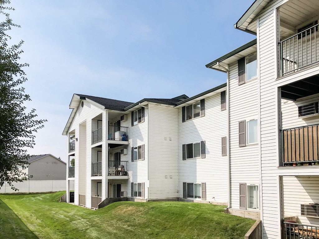 a view of apartments with balconies surrounded by green grass. at North Pointe, Post Falls, ID 83854