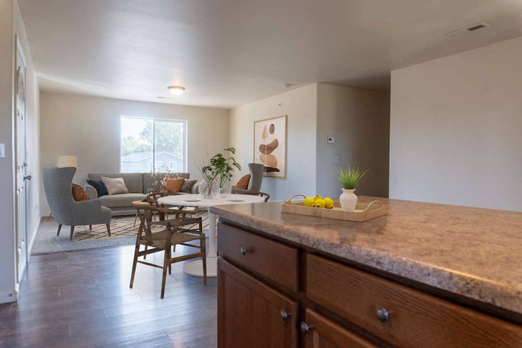 Kitchen breakfast bar looks into the dining area and living room filled with natural light. Staged dining set. at Pine Tree Park, Kennewick, WA