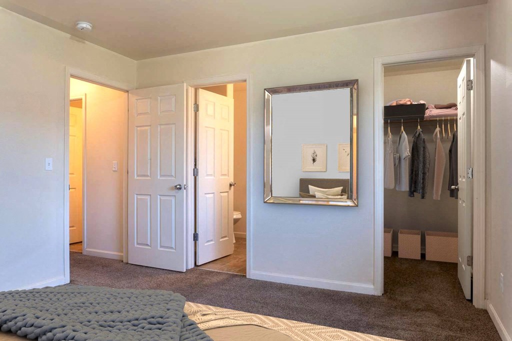 Carpeted bedroom with ensuite on the back left wall and large closet to the right with shelving. at Pine Tree Park, Kennewick, 99337