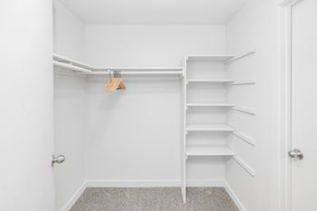 A white closet with a hanger and shelves.