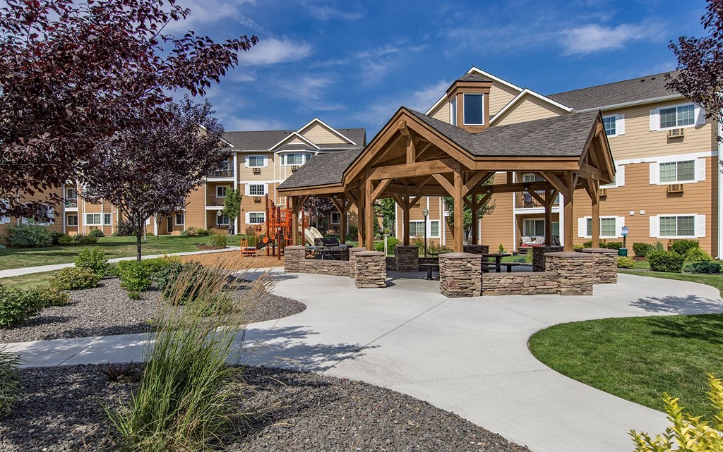 a pavilion with a sidewalk in front of an apartment building