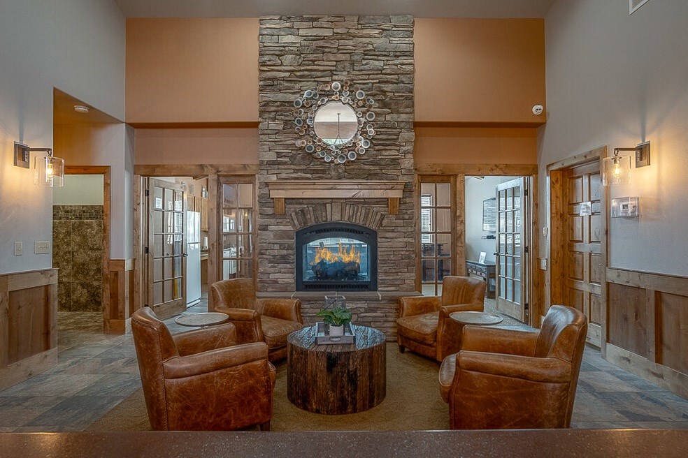 Quail Springs clubhouse with large stone fire place and 4 leather chairs