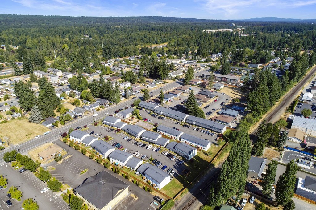 Exterior community ariel view, property is lined with trees, grass, and mountain tops in the background.at Quilceda Gardens, Washington, 98270