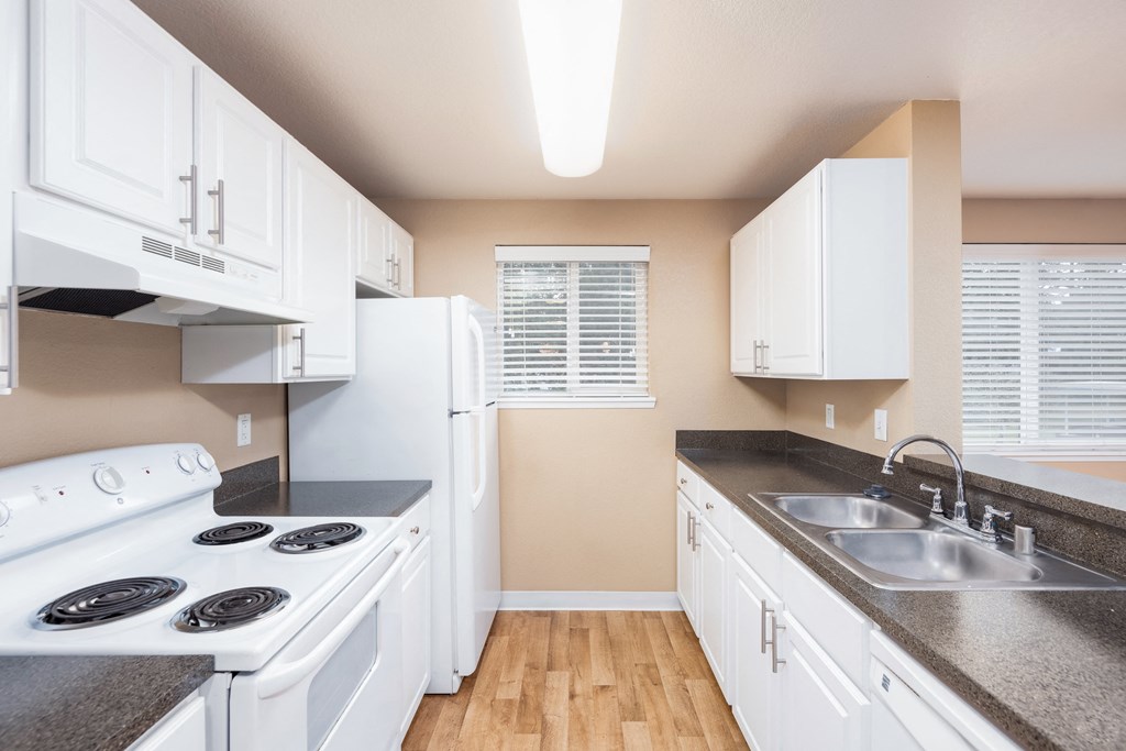 a kitchen with white appliances and counter tops and a sink
