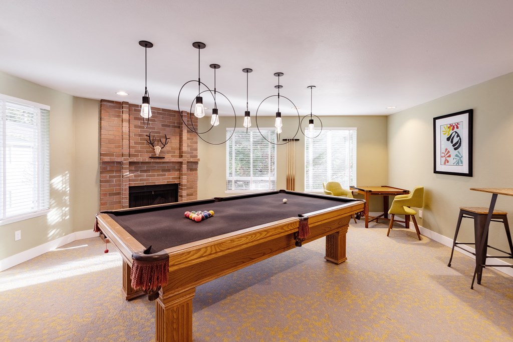 a living room with a pool table and a fireplace