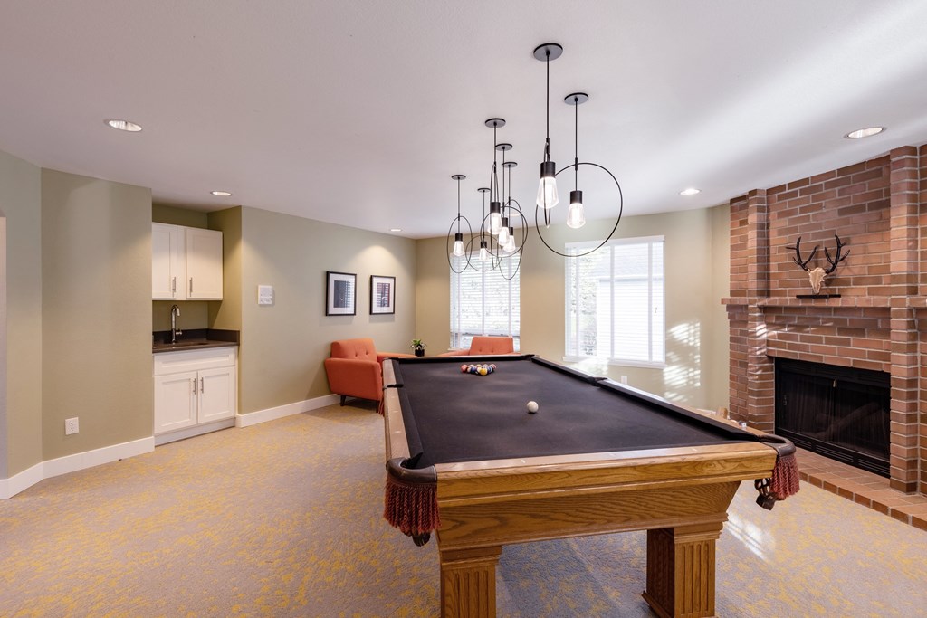 a game room with a pool table and a fireplace