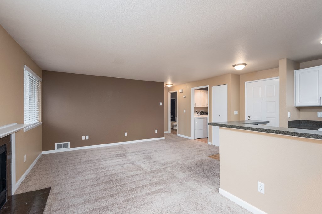 the living room and kitchen of an empty house