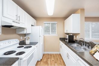 a kitchen with white cabinets and a white stove top oven at Springfield, Renton, WA
