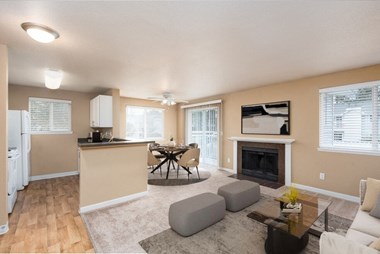 a living room with a fireplace and a dining room in the background