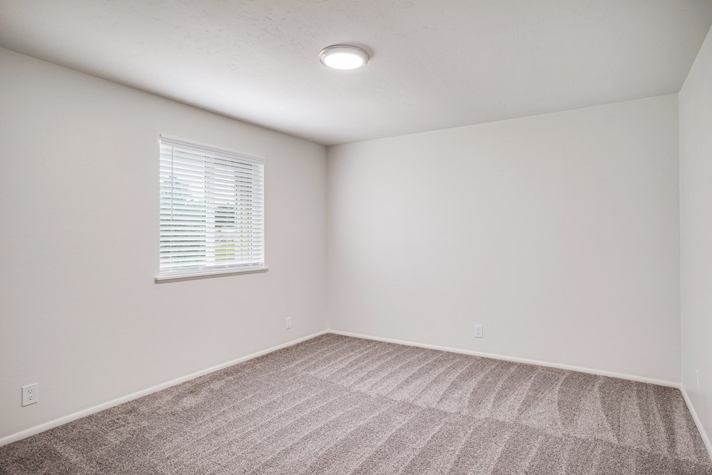 an empty room with carpet and a window