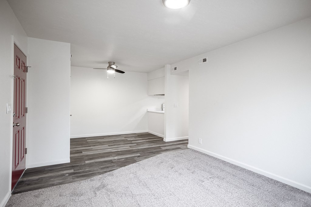 an empty living room with white walls and wood flooring