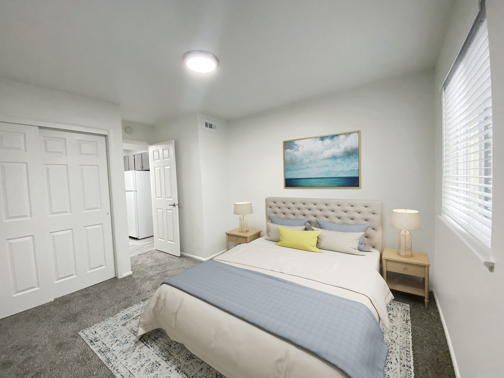 Carpeted bedroom with double sliding door closet on left and large window on right. Staged with queen-size bed and side tables.at Summit, Pocatello, 83201