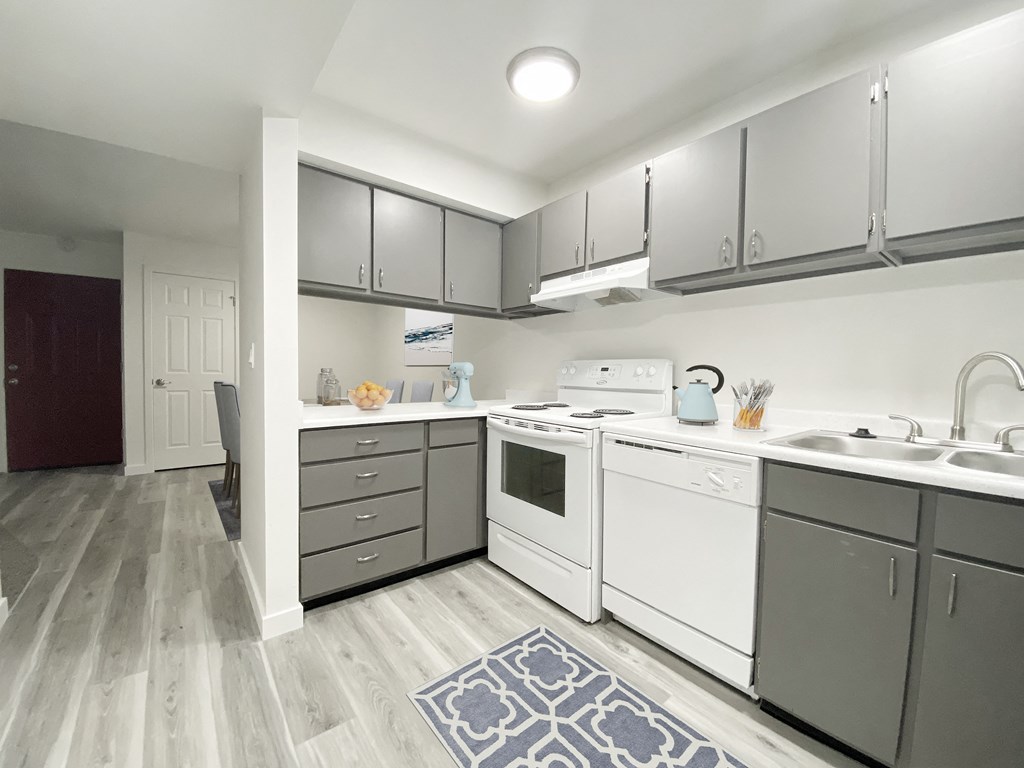 Kitchen with wood-like flooring, gray top, and bottom cabinets, looking down hallway into the dining area.at Summit, Idaho