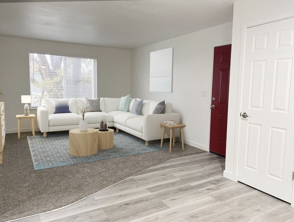 Living room with oversized window on back wall, front door, and closet on right. Staged with l-shaped couch, side tables, rug.at Summit, Pocatello, ID 83201