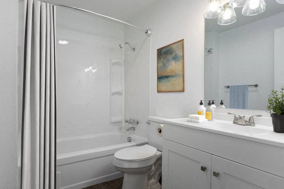 a white bathroom with a shower toilet and sink