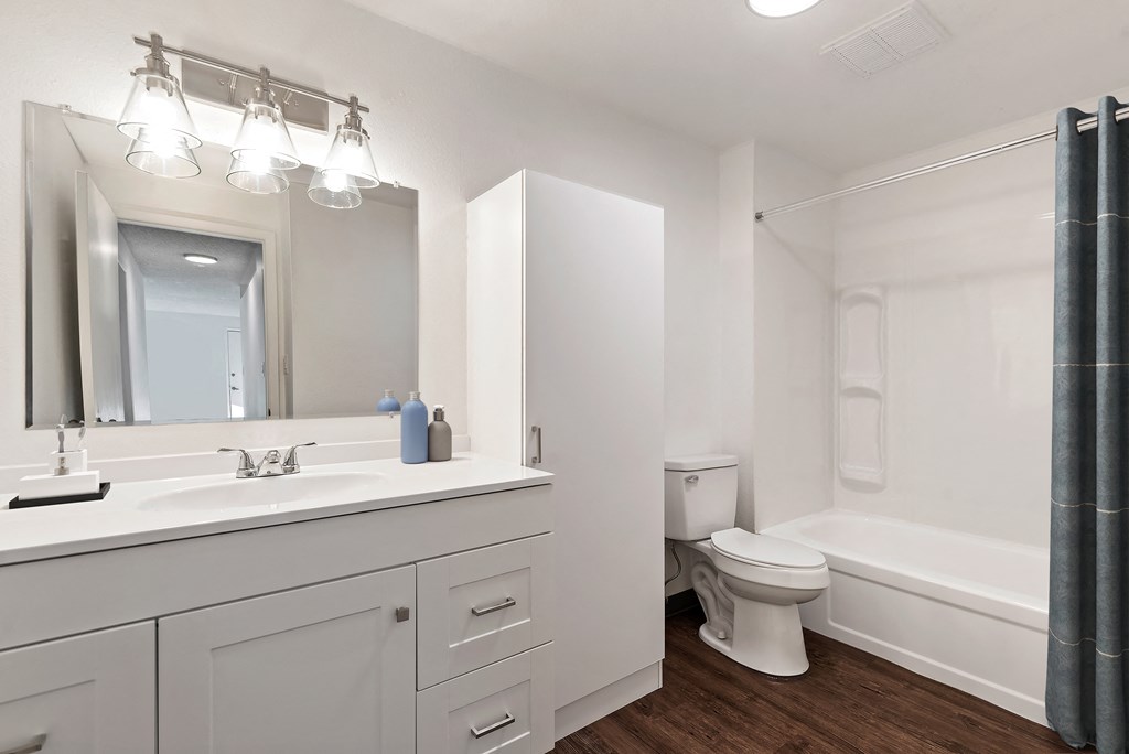 a bathroom with a large mirror and a toilet and a sink
