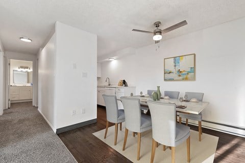 a dining room with a table and chairs and a ceiling fan