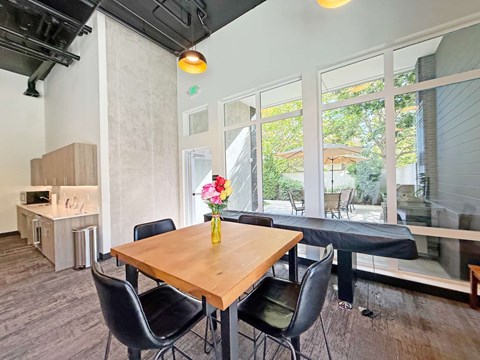 A dining room with a wooden table and chairs at The Duo Apartments in University Place, WA.