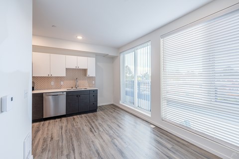 A kitchen with white cabinets and a stainless steel dishwasher.