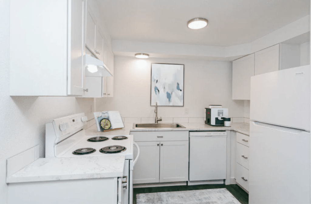 a white kitchen with white appliances and white cabinets