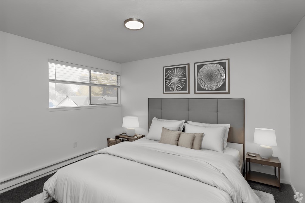 bedroom with white walls and a white bed with white sheets and pillows