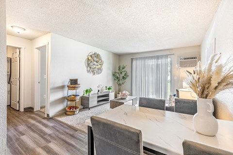 A dining room with a white table and grey chairs at Wildflower Apartments in Kennewick, WA..