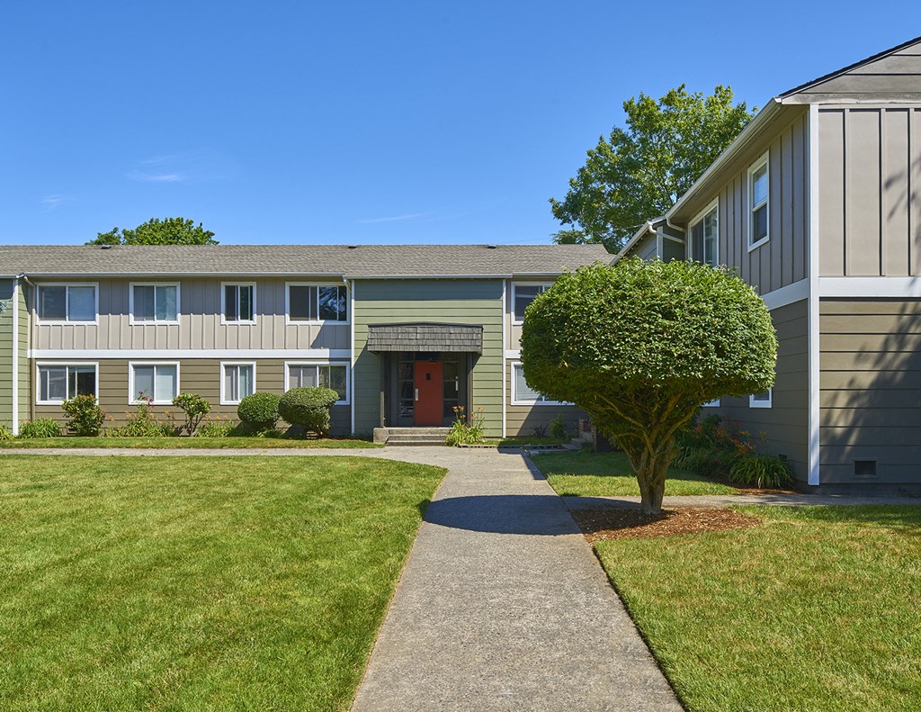 Exterior grounds with paved pathway leading through large grass area to homes.at Woodhaven, Everett, Washington