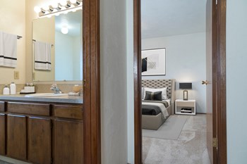 Bathroom Ensuite room with large bathroom counter, sink, wood under sink cabinets, hand towel rack, and good lighting. - Photo Gallery 2