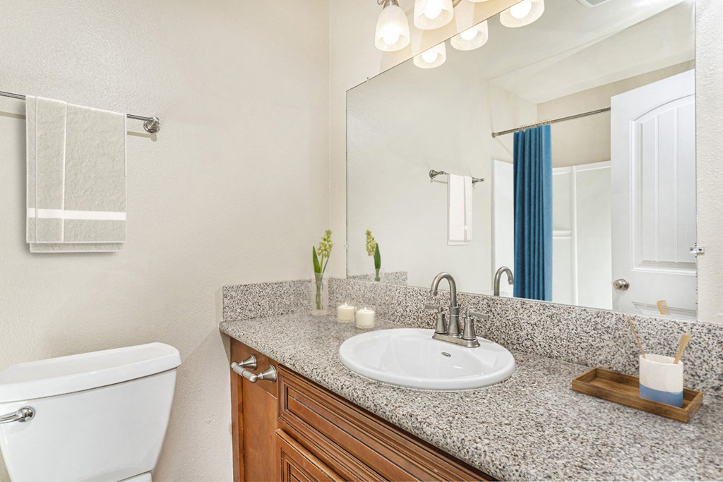 Apartment bathroom with towel rack, shower with tub and a large quartz countertop at Pacific Sands, San Diego, 92117