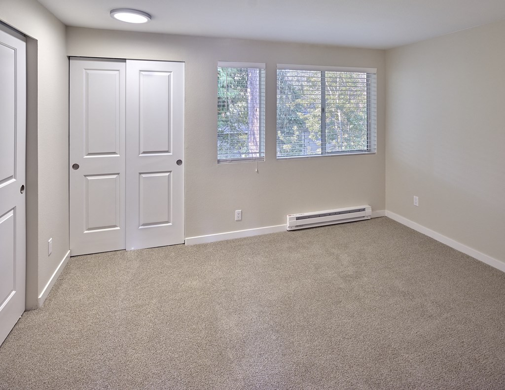 an empty room with carpet and a white door and window