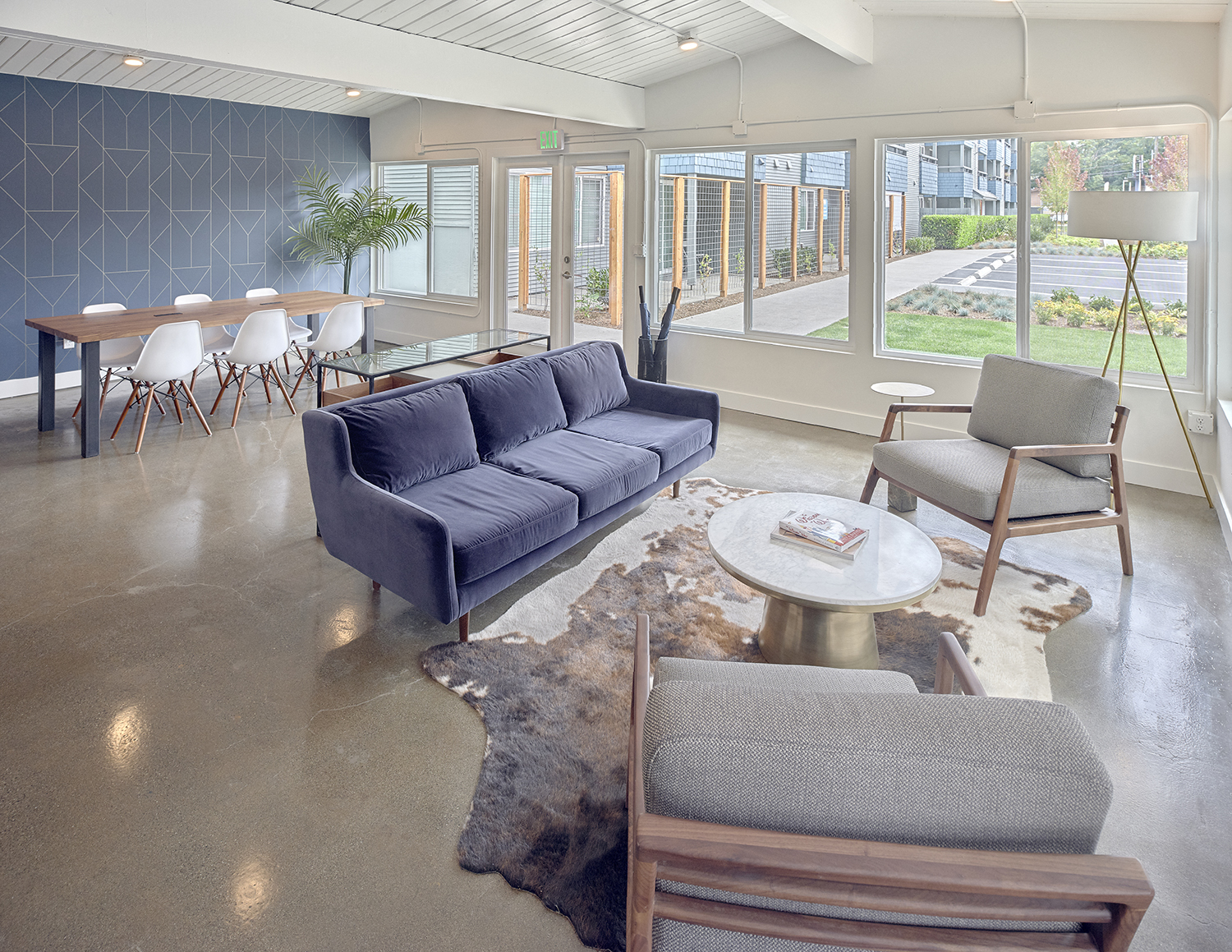 Clubhouse with lots of windows and natural light. Laminated stone floors. Casual seating with a couch, and two chairs. Table seating near windows. at 3030 Lake City, Washington