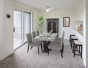 Dining Room Dining area with table and chairs in the center, a ceiling fan with light, sliding glass doors to the left, and a breakfast bar on the right. - Photo Gallery 2