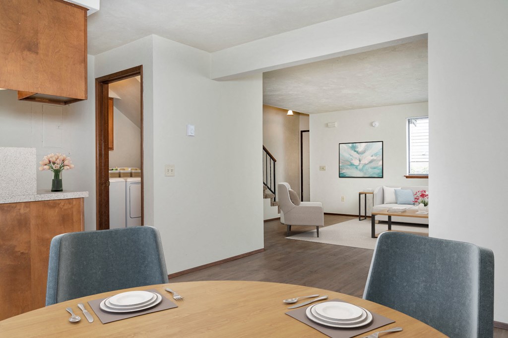 Open-concept dining area with wood-style flooring, table, and 2 chairs. Looking into the large living room to the right. at Hawks Prairie, Olympia, 98516