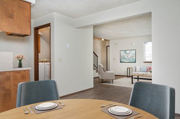Dining area Open-concept dining area with wood-style flooring, table, and 2 chairs. Looking into the large living room to the right. - Photo Gallery 3