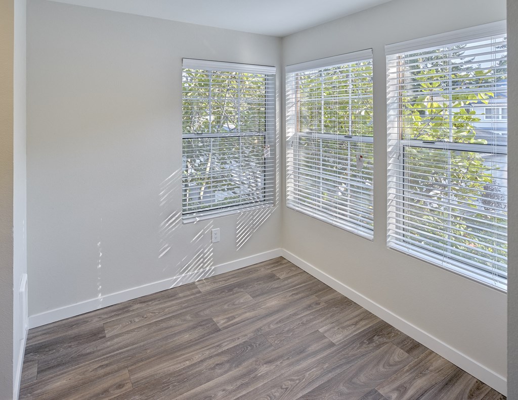 an empty room with wood flooring and three windows  at Edmonds Gateway, Edmonds, WA, 98026