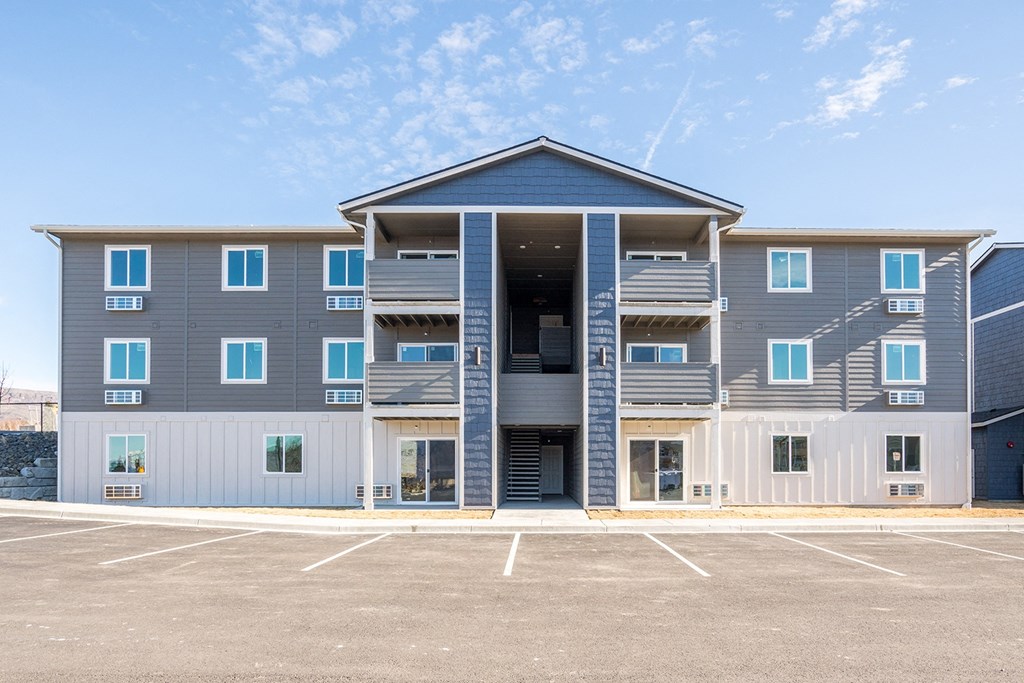 Exterior image of building. Blue, grey, and white siding and outdoor access to units. Exterior image of building. Blue, grey, and white siding and outdoor access to units. at Altitude, East Wenatchee