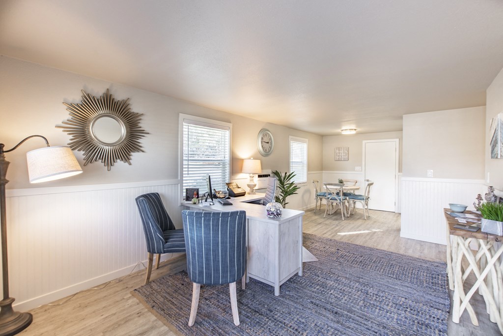 Property office showing comfortable chairs, desk, floor lamp and side table at The Lakes Apartments, Moses Lake, WA.