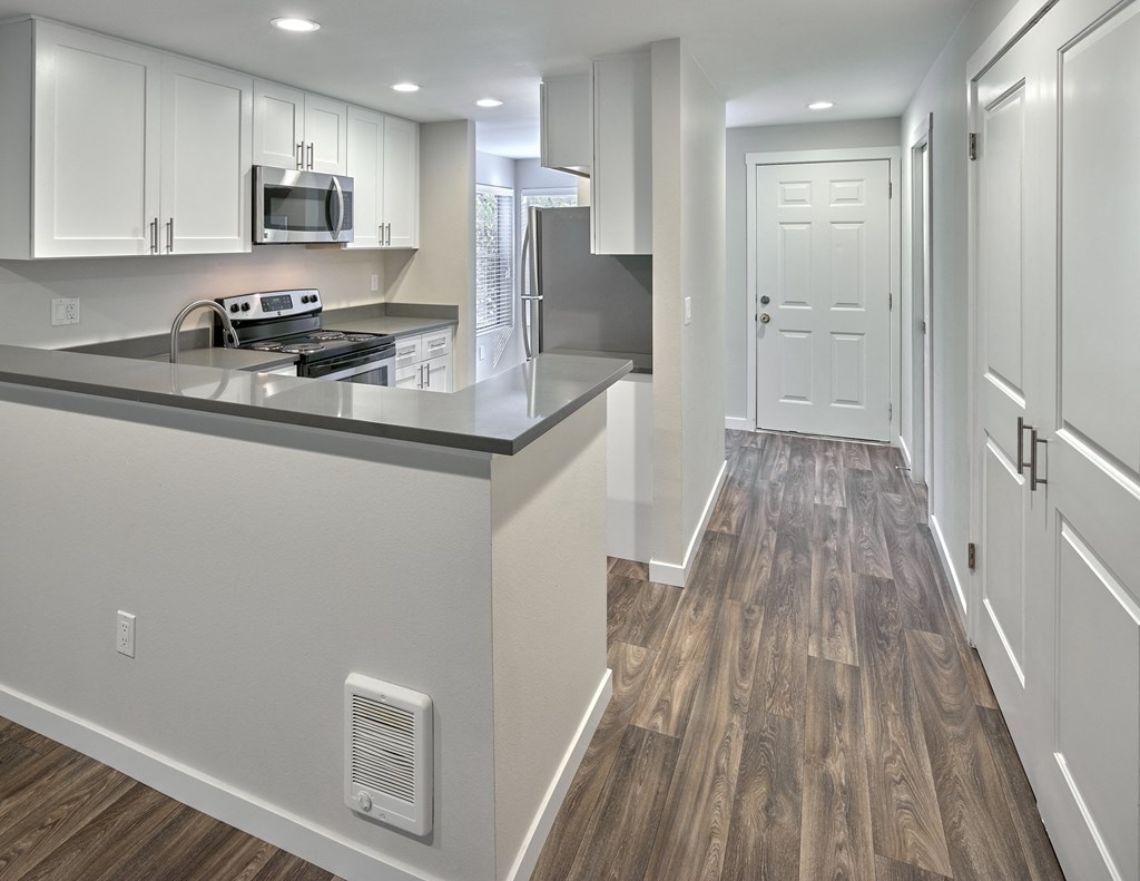 a renovated kitchen with white cabinets and stainless steel appliances at Edmonds Gateway, Edmonds, WA 98026