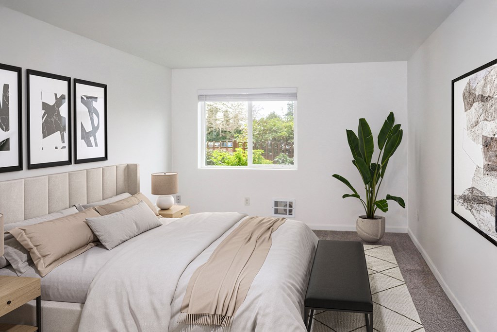A large bedroom with a potted plant and a large window at our Renton Apartments