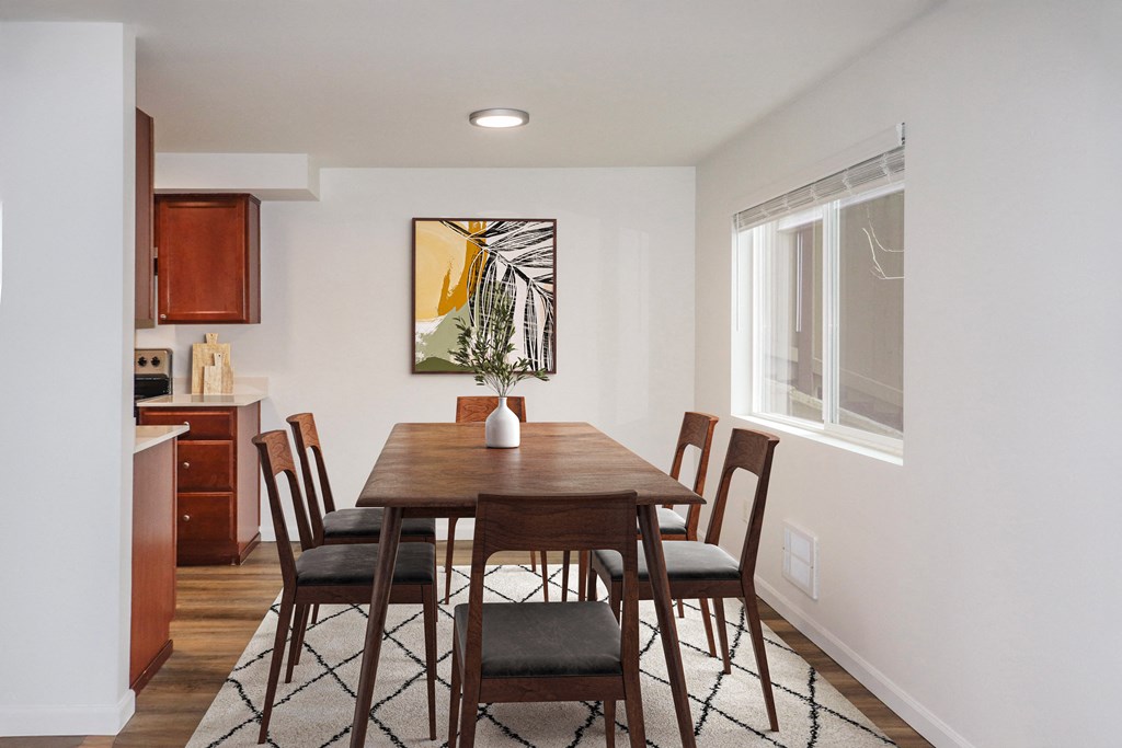 a kitchen and dining area with a carpeted floor and large window at Heritage Grove Apartments in Renton, WA