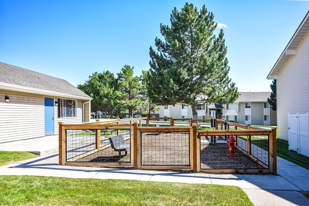 Kirkwood Meadows dog run with fence and a fire hydrant surrounded by green grass and trees in Pocatello, ID