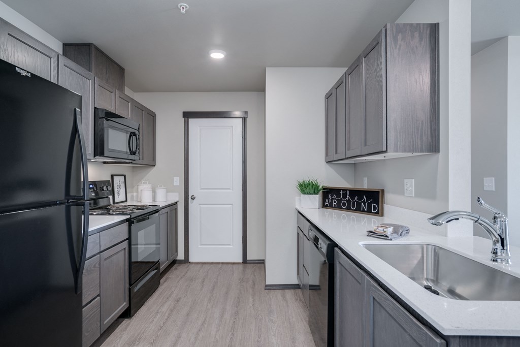 Length perspective of kitchen. with countertops on each side. Pantry door at the end of the kitchen. at Altitude, East Wenatchee, 98802