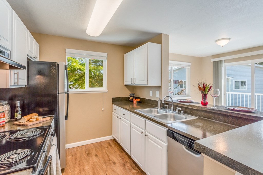 a kitchen with white cabinets and a sink and a refrigerator at Springfield, Renton Washington